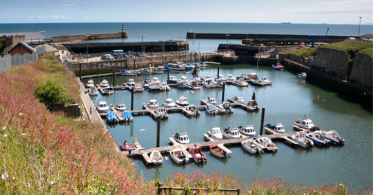 view of boats in Seaham Marina on a sunny day with lighthouse in background
